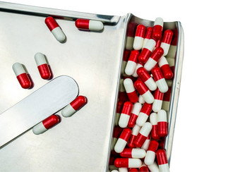 前视图红色的白色抗生素胶囊药片孤立的不锈钢钢药物托盘剪裁路径药物电阻概念药物合理的
