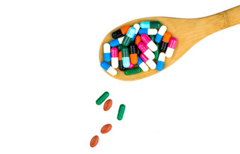 色彩斑斓的胶囊药片木勺子溢出孤立的白色背景复制空间剪裁路径抗生素药物合理的健康保险概念