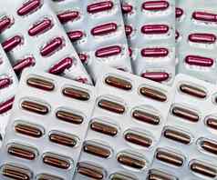 堆红色的胶囊药片泡包维生素补充概念制药包装行业药店背景