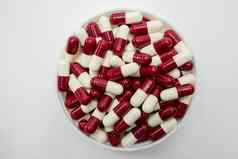 前视图红色的白色胶囊药片塑料容器白色背景抗生素药物电阻