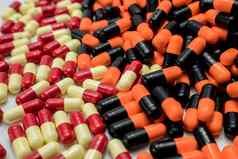 橙色黑色的红色的苍白的黄色的胶囊药片制药行业抗生素药物电阻药店背景药物的相互作用