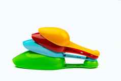 集色彩斑斓的塑料测量勺子孤立的白色背景影子绿色蓝色的红色的橙色塑料测量勺子