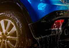蓝色的紧凑的运动型多功能车车体育运动设计洗水肥皂车护理服务业务概念汽车覆盖滴水白色泡沫清洁水泡沫喷雾