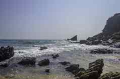 海海滩湾印度海洋果阿印度翡翠波海洋蓝色的天空岩石海岸线结束海海岸山海岸线填满岩石蓝色的波日落