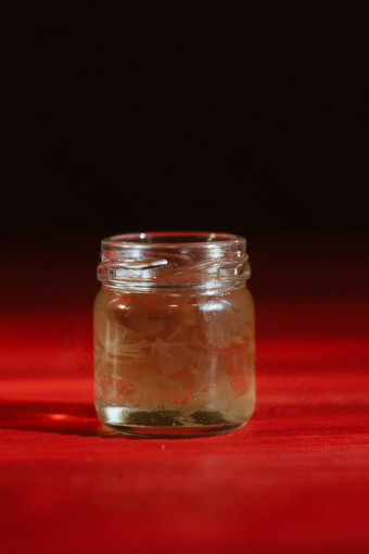 蜂蜜玻璃Jar关闭黑色的背景红色的木表格对于蜂蜜坚持蜂蜜七星