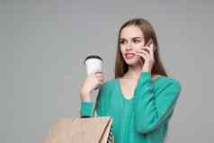 女孩绿色袋喝咖啡会谈智能手机