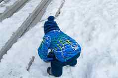 男孩蓝色的针织他温暖的夹克戏剧冬天楼梯覆盖雪视图回来