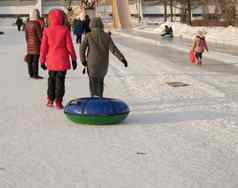 青少年女孩拉油管滑动坡冰幻灯片冬天有趣的公园
