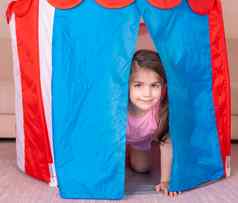 肖像可爱的女孩戏剧隐藏色彩斑斓的玩具帐篷