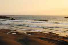 海洋日落明亮光金海景温柔的波滚动海岸