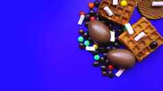 美味的巧克力复活节鸡蛋糖果黑暗蓝色的背景