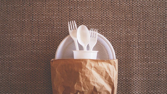 白色塑料菜纸包米色背景