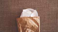 白色皱巴巴的塑料菜纸包米色背景