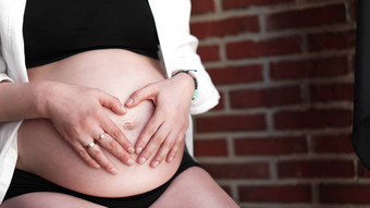 怀孕了女人持有手心形状婴儿撞