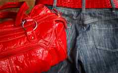 蓝色的牛仔裤红色的手提包