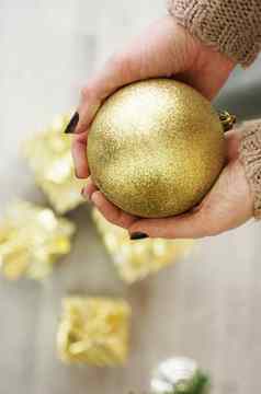 手持有黄金球装饰圣诞节树背景