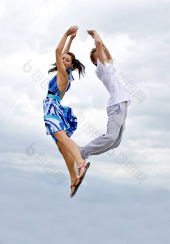肖像快乐年轻的夫妇跳空气天空
