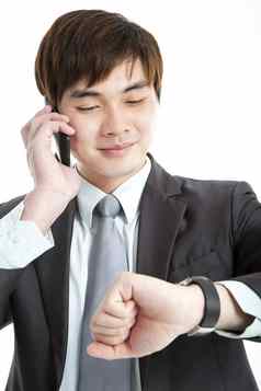 亚洲商人检查时间会说话的移动电话