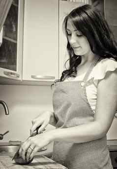 浅黑肤色的女人切片番茄厨房黑色的白色照片