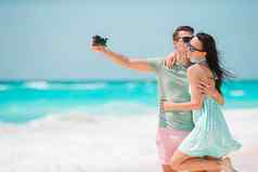 快乐夫妇采取照片白色海滩度蜜月假期