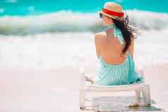 年轻的女人享受太阳日光浴完美的绿松石海洋