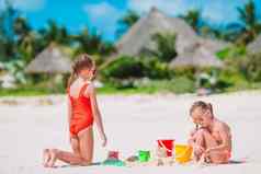 孩子们使沙子城堡有趣的热带海滩