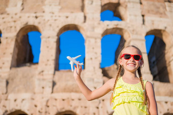 可爱的女孩小玩具模型飞机背景罗马圆形大剧场罗马意大利