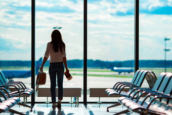 年轻的女人国际机场行李背景大窗口航空公司乘客机场休息室等待飞行飞机