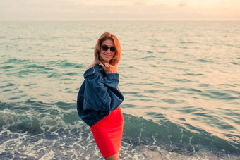 户外时尚肖像时尚的女孩穿时尚的太阳镜牛仔裤夹克海滩手复古的<strong>过滤</strong>器斑点阳光