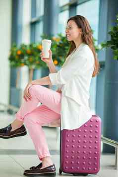 年轻的女人国际机场行李咖啡等待飞行