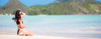 女人坐着海滩笑享受夏天假期相机美丽的模型<strong>比基尼</strong>坐着