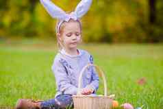 可爱的女孩穿兔子耳朵篮子完整的复活节鸡蛋春天一天在户外