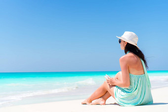 女人坐着海滩享受夏天假期