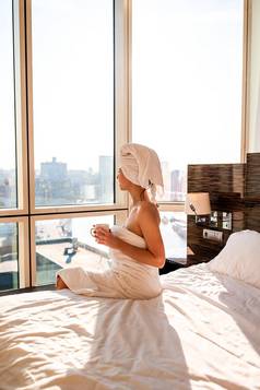 美丽的年轻的女人白色浴毛巾头放松淋浴床上杯咖啡