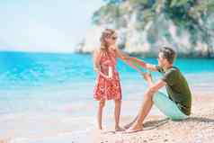 年轻的爸爸应用太阳奶油女儿鼻子海滩太阳保护