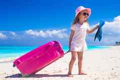 可爱的女孩大行李手热带海滩