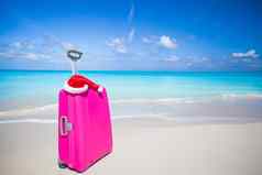 特写镜头粉红色的手提箱圣诞老人老人他海滩
