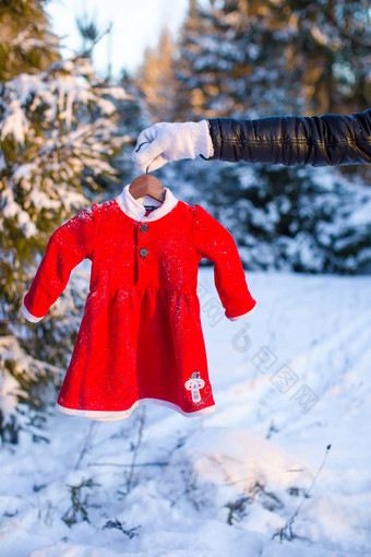 儿童红色的圣诞老人衣服雪冷杉森林