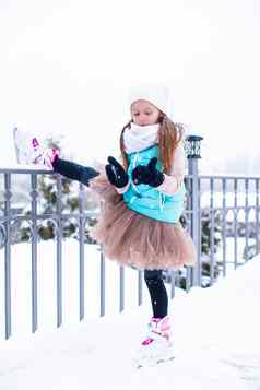 可爱的女孩滑冰冰溜冰场在户外冬天雪一天