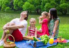 快乐年轻的家庭野餐在户外湖