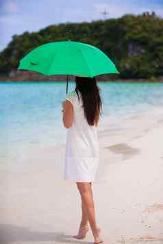 年轻的女孩伞白色海滩