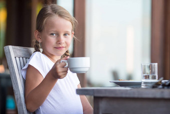 可爱的女孩喝茶早餐户外咖啡馆