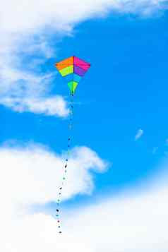 色彩斑斓的风筝飞行风背景蓝色的天空