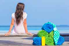 海滩夏天配件概念色彩斑斓的毛巾泳衣sunsblock背景美丽的女人