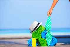 海滩夏天假期配件概念特写镜头色彩斑斓的毛巾他袋防晒霜