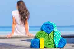 海滩夏天配件概念色彩斑斓的毛巾泳衣sunsblock背景美丽的女人
