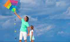 快乐父亲女孩飞行风筝热带海滩