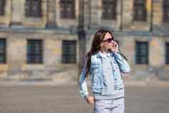 年轻的高加索人女人会说话的细胞电话街道欧洲城市