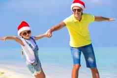 女孩快乐父亲圣诞老人帽子享受圣诞节假期