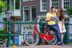 年轻的游客夫妇地图自行车欧洲城市